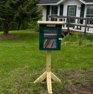 Small wooden box on a stand filled with books