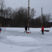 students in boots playing hockey on an ice rink